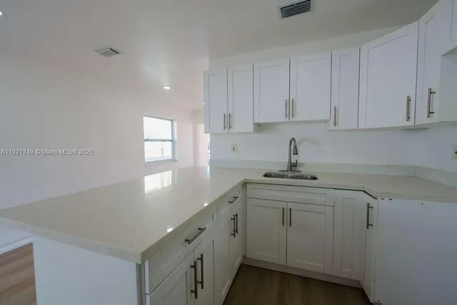 a kitchen with cabinets appliances a sink and a window
