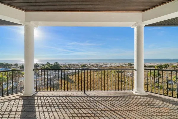 a view of a patio with a table and chairs potted plants and swimming pool