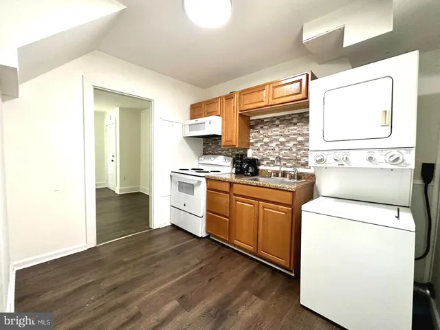 a kitchen with granite countertop white cabinets and white appliances