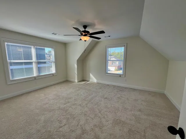 an empty room with windows and fan