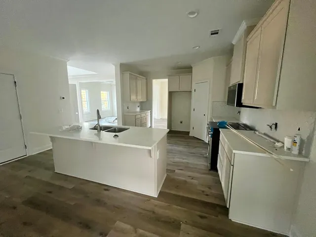 a view of living room with stainless steel appliances wooden floor and view living room