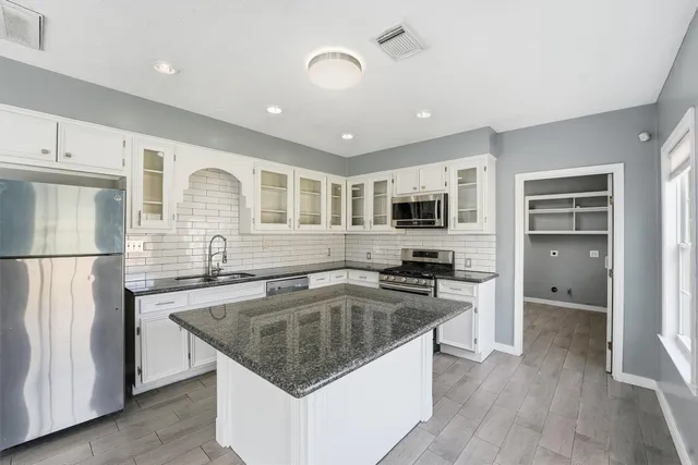 a kitchen with stainless steel appliances granite countertop a sink stove and refrigerator