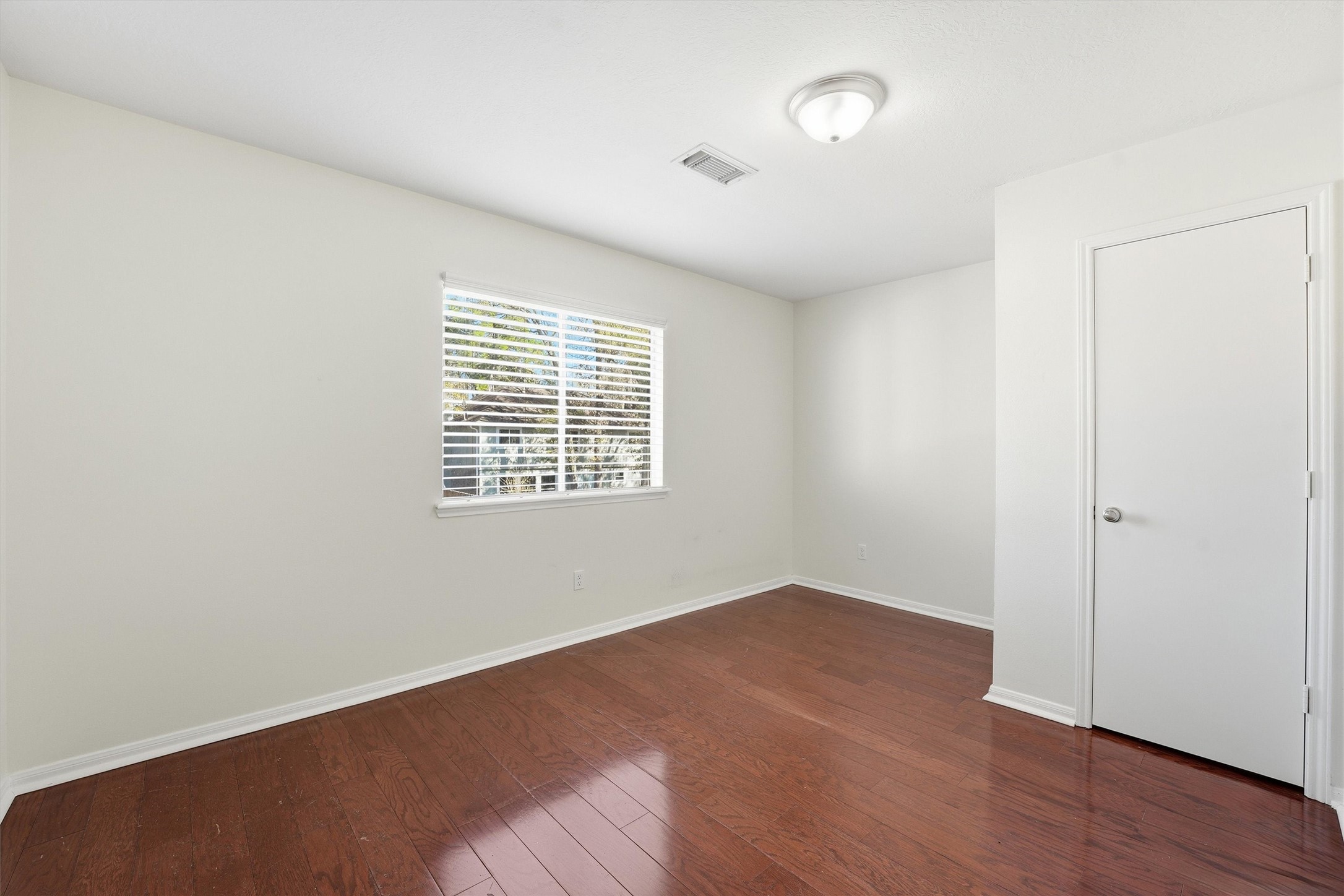 18385 Ten Oaks Court Porter, TX 77365 - Photo 16 of 31 an empty room with wooden floor and windows