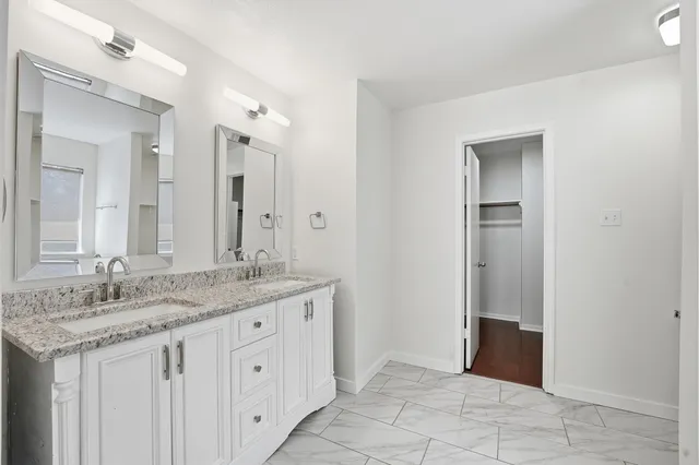 a spacious bathroom with a granite countertop sink and a mirror