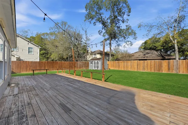 a view of a yard with wooden fence