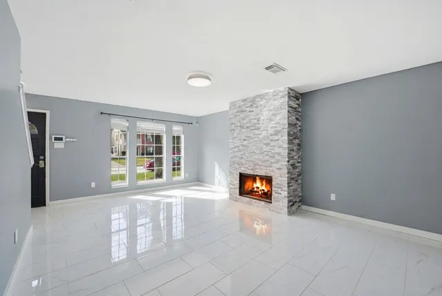 a view of an empty room with a fireplace and a window
