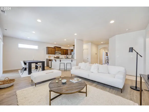a living room with furniture and view of kitchen
