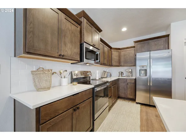 a kitchen with stainless steel appliances granite countertop a sink a stove and a refrigerator