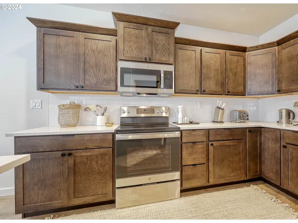 a kitchen with stainless steel appliances granite countertop a sink stove and cabinets