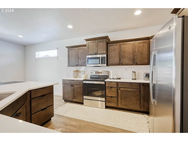 a kitchen with stainless steel appliances granite countertop a refrigerator and a stove top oven
