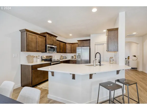 a kitchen with stainless steel appliances a table and chairs