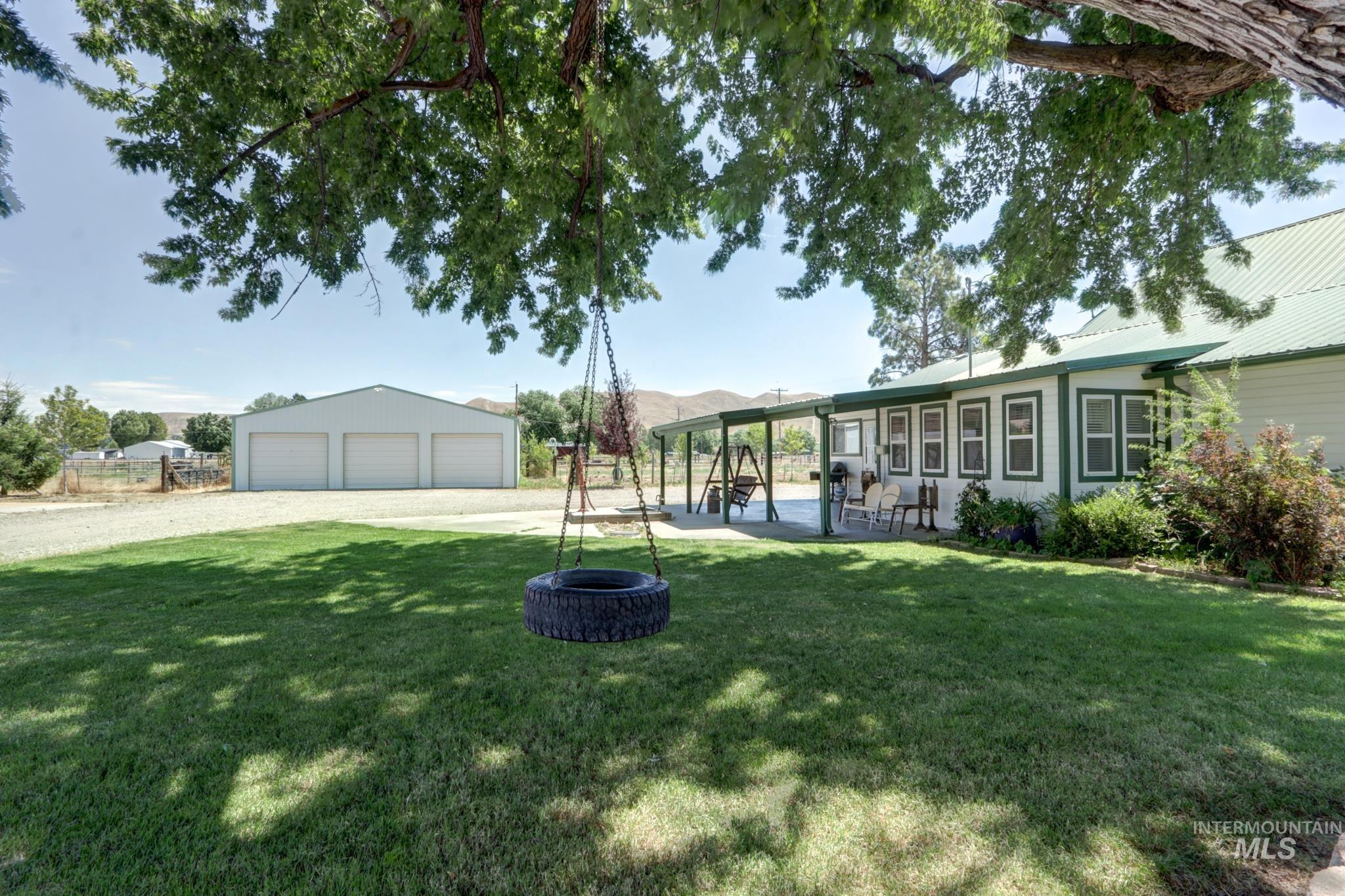 2528 Waterwheel Road Emmett, ID 83617 - Photo 4 of 50 White-sided home featuring a green metal roof and a covered front porch with white columns