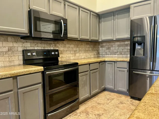 a kitchen with stainless steel appliances granite countertop a stove microwave and refrigerator