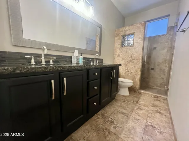 a bathroom with a granite countertop sink toilet and shower
