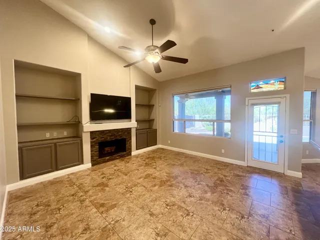a view of empty room with a fireplace and flat screen tv