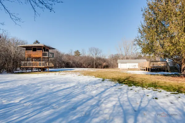 a view of a house with backyard and tree