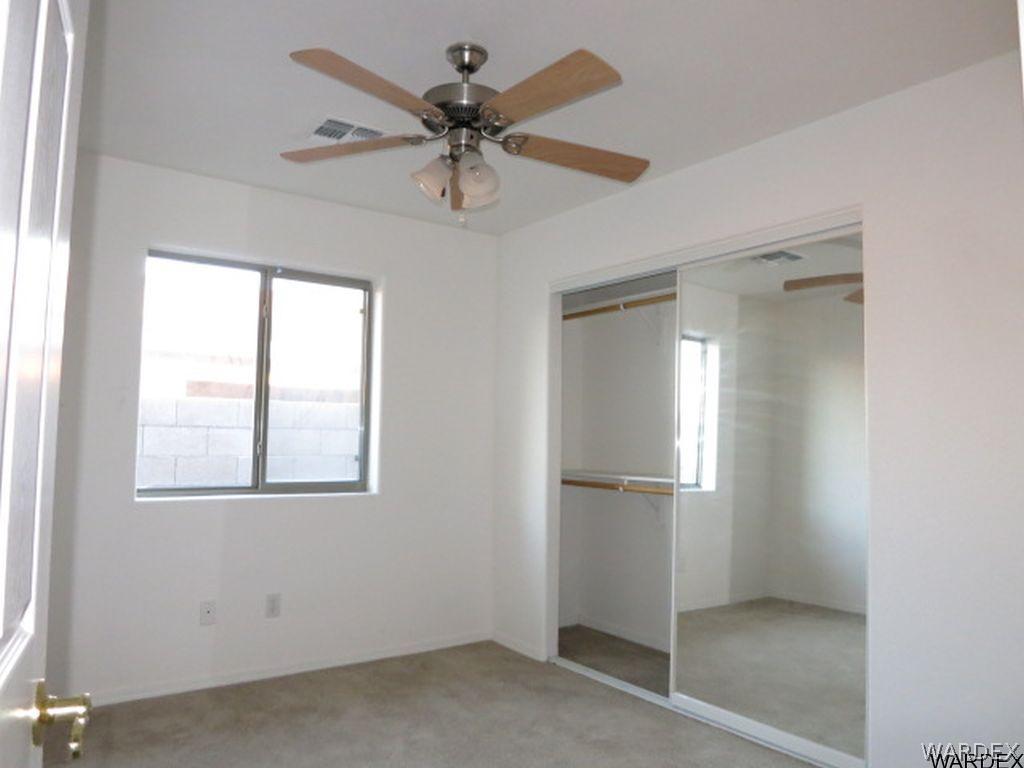 3661 North Kenneth Road Kingman, AZ 86409 - Photo 11 of 18 an empty room with chandelier fan and windows