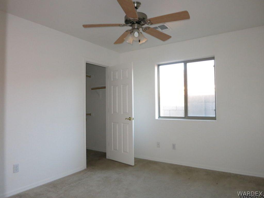 3661 North Kenneth Road Kingman, AZ 86409 - Photo 12 of 18 an empty room with a window and a fan