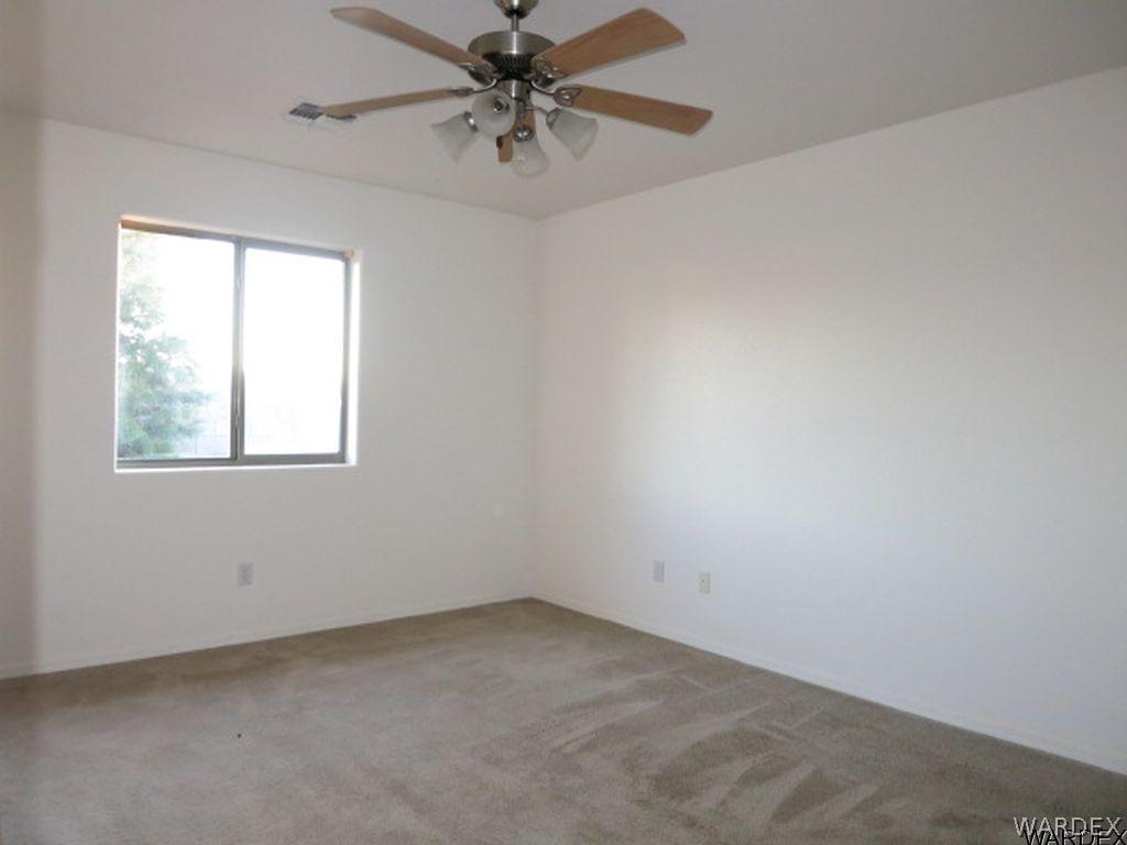 3661 North Kenneth Road Kingman, AZ 86409 - Photo 13 of 18 an empty room with a window and a fan
