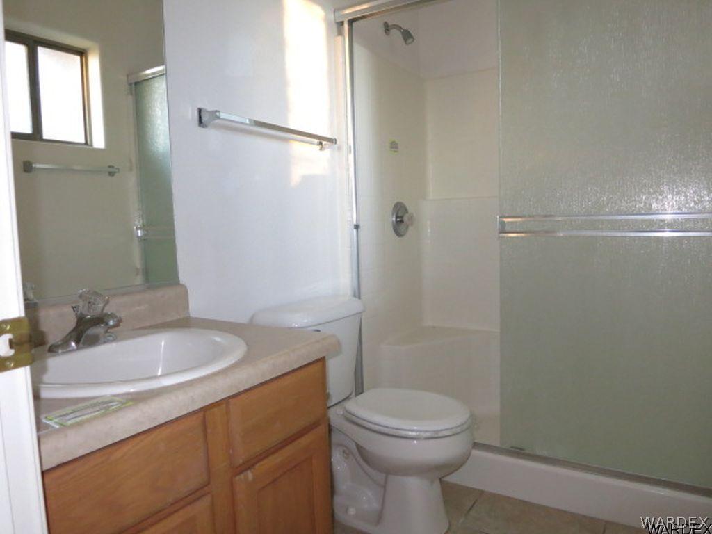 3661 North Kenneth Road Kingman, AZ 86409 - Photo 14 of 18 a bathroom with a granite countertop sink toilet and shower