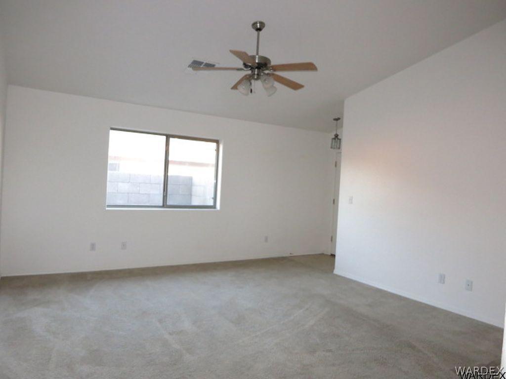 3661 North Kenneth Road Kingman, AZ 86409 - Photo 8 of 18 an empty room with a ceiling fan and windows