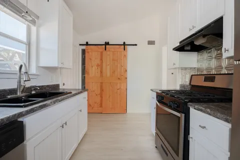 a kitchen with stainless steel appliances granite countertop a sink stove and refrigerator
