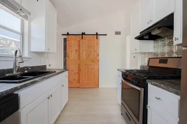 a kitchen with stainless steel appliances granite countertop a sink stove and refrigerator