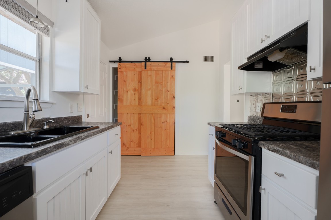 3301 Doolin Drive Austin, TX 78704 - Photo 15 of 32 a kitchen with stainless steel appliances granite countertop a sink stove and refrigerator