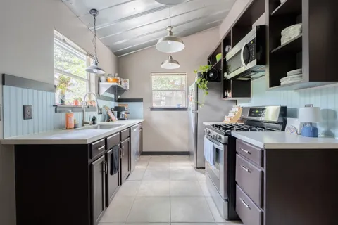 a kitchen with stainless steel appliances granite countertop a sink stove and refrigerator