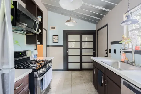 a kitchen with stainless steel appliances granite countertop a sink stove and cabinets