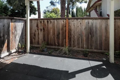 a view of a house with backyard and wooden fence