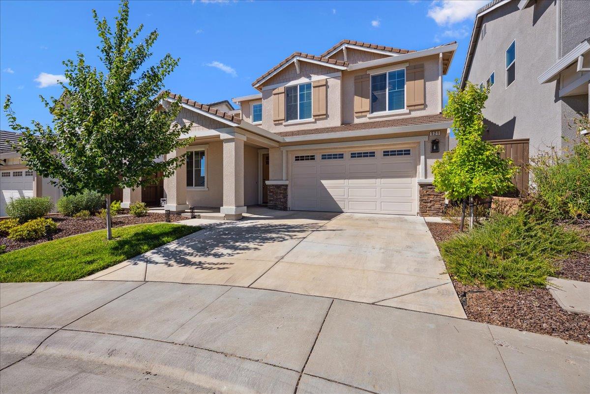 a front view of a house with a yard and trees