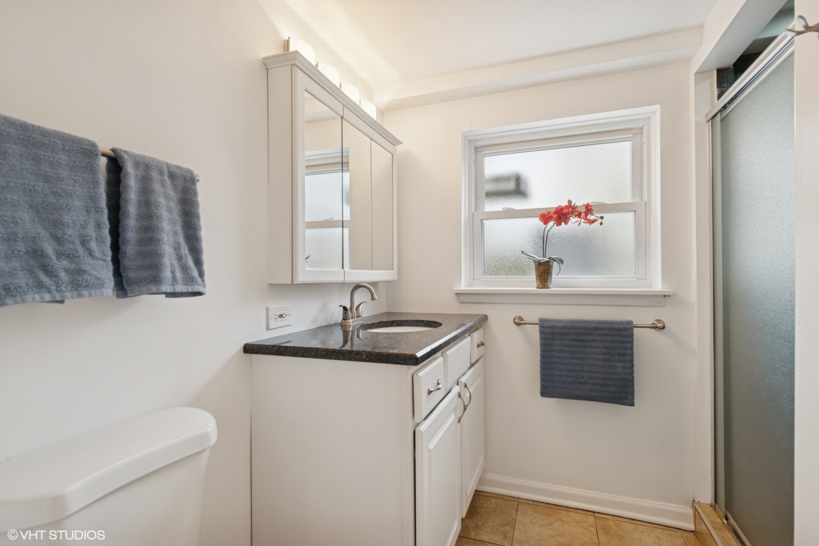 418 Warren Road Glenview, IL 60025 - Photo 13 of 24 a bathroom with a granite countertop sink a mirror and a toilet