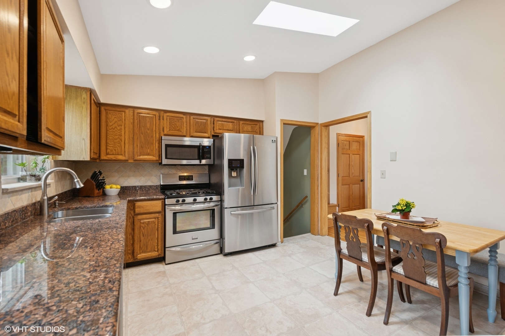 418 Warren Road Glenview, IL 60025 - Photo 6 of 24 a kitchen with stainless steel appliances granite countertop a stove refrigerator sink and cabinets