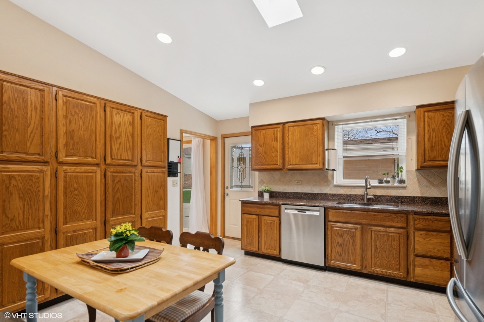 418 Warren Road Glenview, IL 60025 - Photo 7 of 24 a kitchen with stainless steel appliances kitchen island granite countertop a sink and cabinets