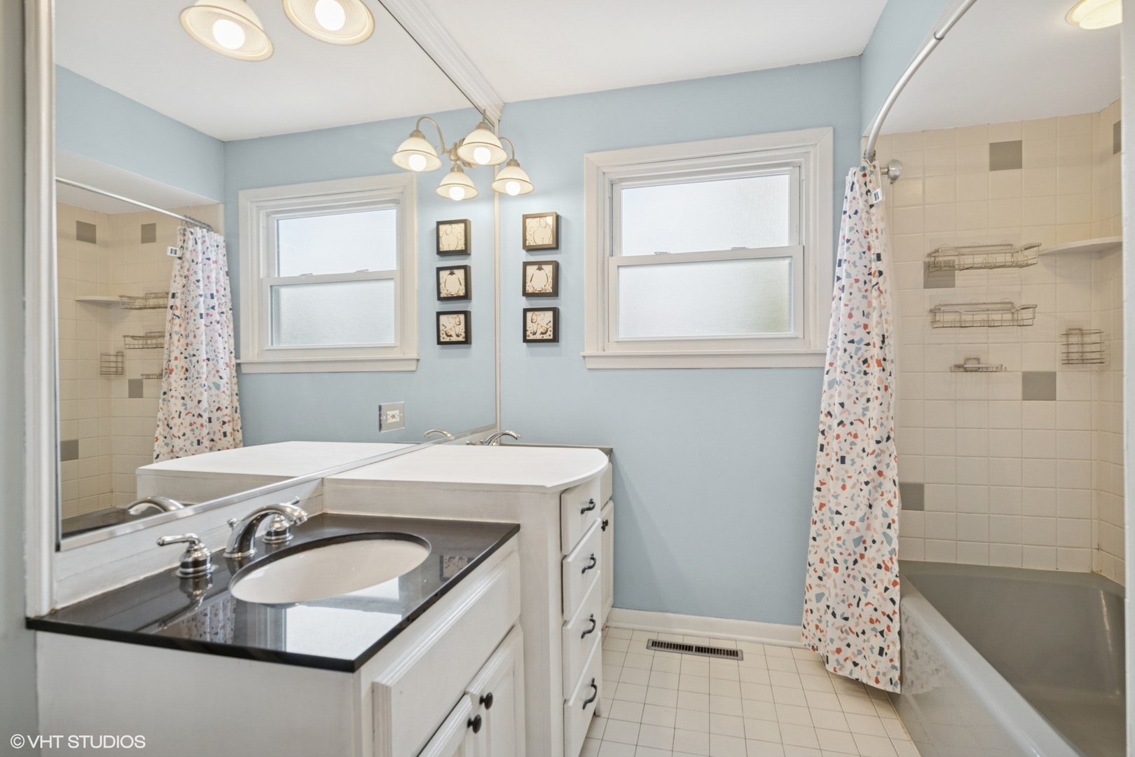 418 Warren Road Glenview, IL 60025 - Photo 10 of 24 a bathroom with a sink a large mirror and a bathtub with shower