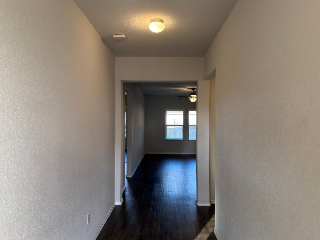 21700 Urraca Lane Pflugerville, TX 78660 - Photo 19 of 40 a view of a hallway with wooden floor and a living room