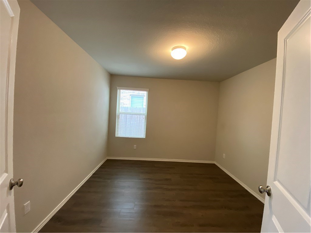 21700 Urraca Lane Pflugerville, TX 78660 - Photo 26 of 40 an empty room with wooden floor and windows
