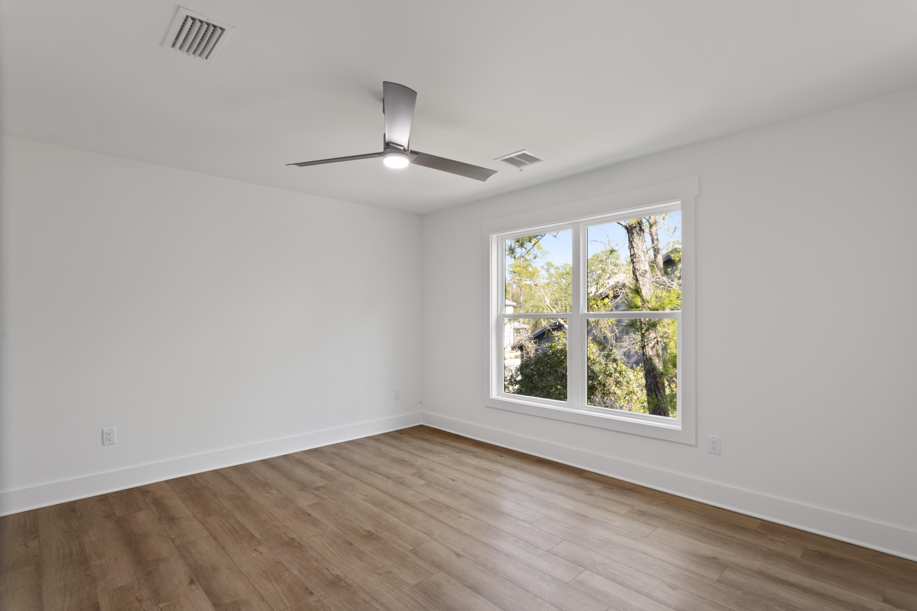 310 Channel Shl Drive, Unit LOT 13 Santa Rosa Beach, FL 32459 - Photo 66 of 77 an empty room with wooden floor chandelier fan and windows