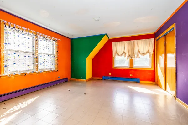a view of an empty room with a fireplace and a flat screen tv