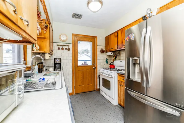 a kitchen with stainless steel appliances granite countertop a refrigerator and a stove