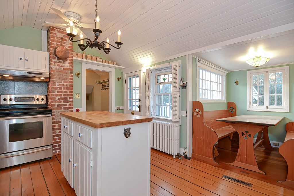 1919 Main Road Westport, MA 02791 - Photo 25 of 42 a kitchen with stainless steel appliances granite countertop a oven a dining table and chairs with wooden floor
