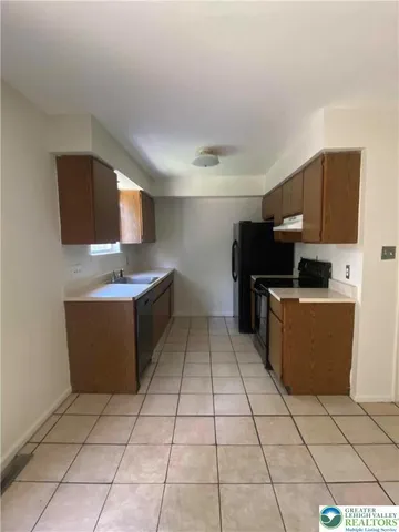 a kitchen with stainless steel appliances a refrigerator a sink a stove top oven and a counter top space