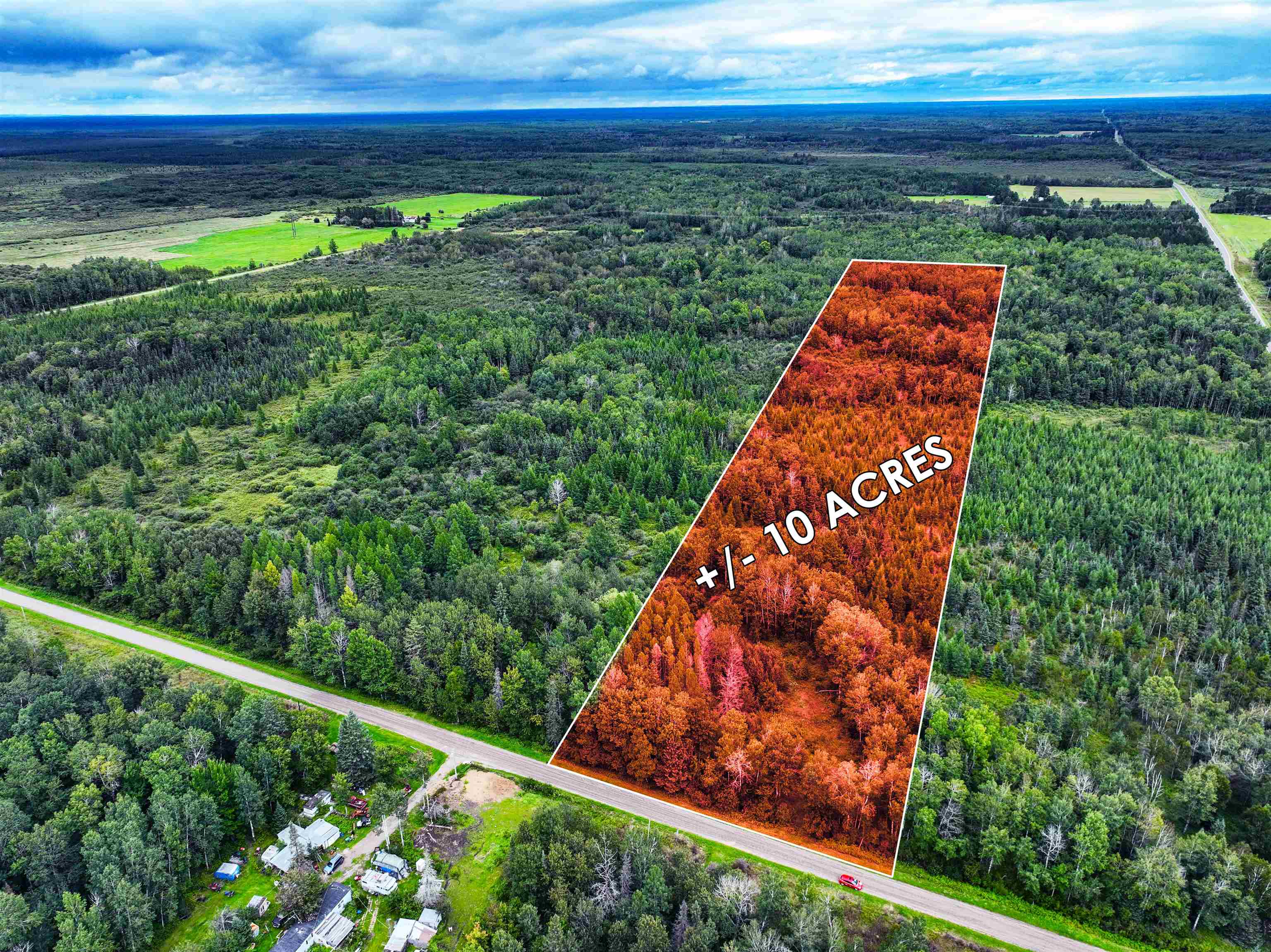 Aerial view of property's location with a heavily wooded area and property parcel outlined