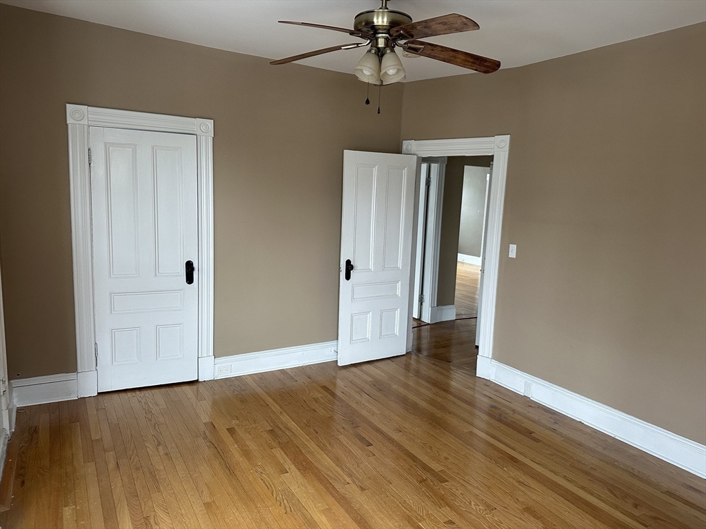 225 Gibson Street, Unit 2 Lowell, MA 01851 - Photo 6 of 13 a view of an empty room with wooden floor