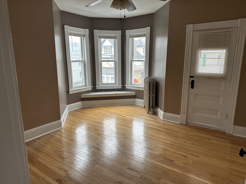 225 Gibson Street, Unit 2 Lowell, MA 01851 - Photo 7 of 13 a view of empty room with wooden floor and fan