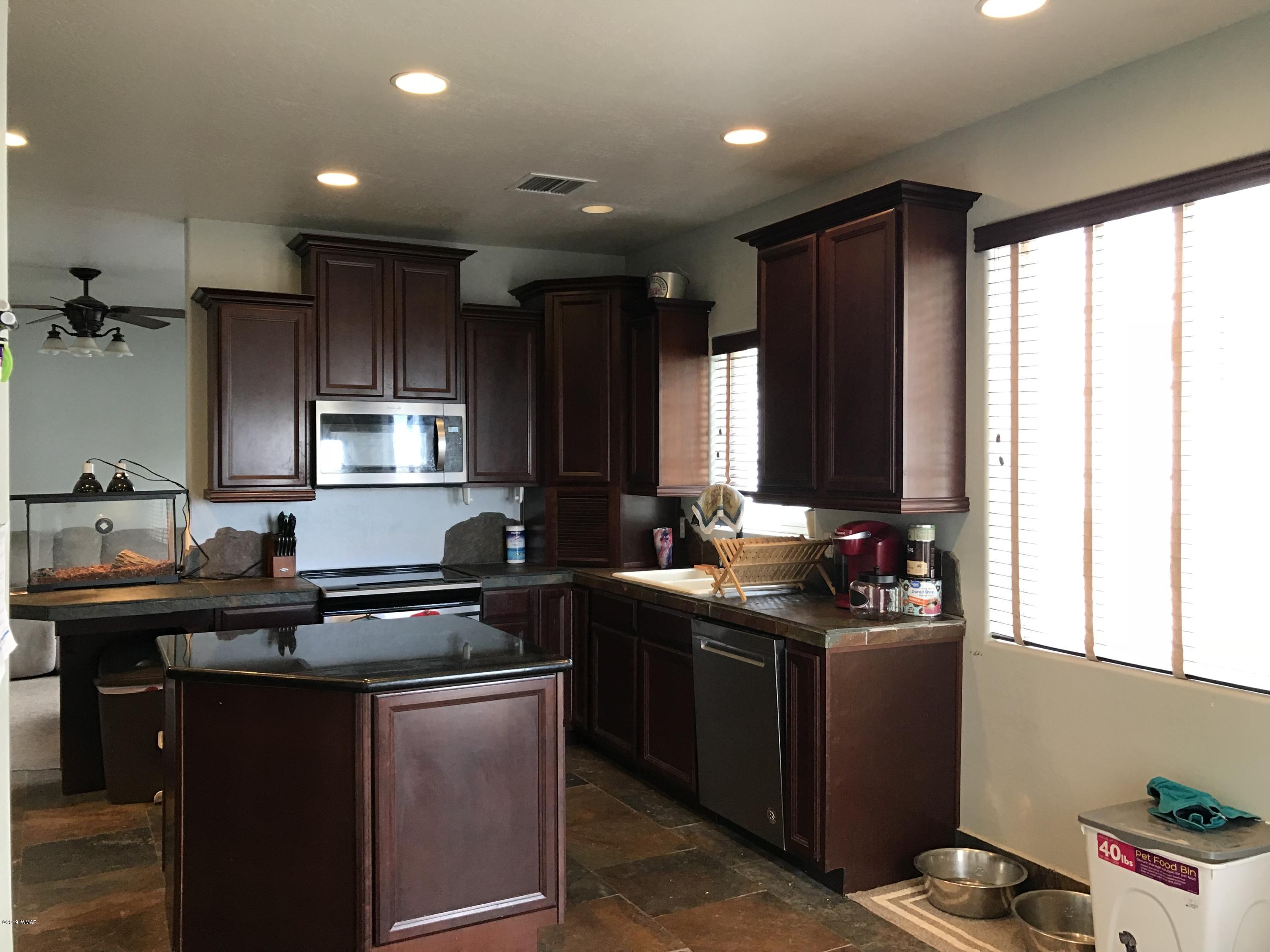 526 South 6th W Street Snowflake, AZ 85937 - Photo 13 of 36 a kitchen with kitchen island granite countertop a sink stove and cabinets