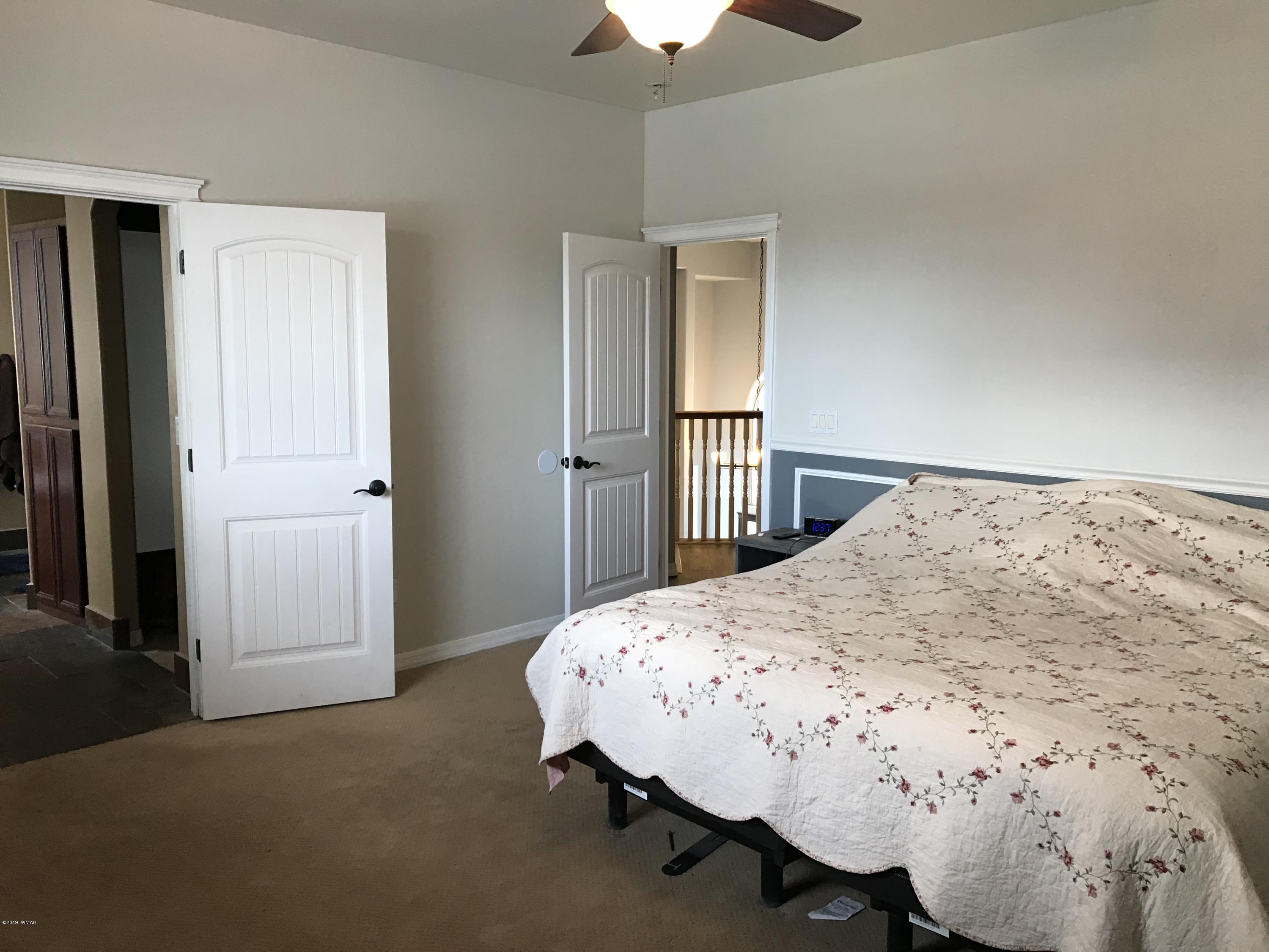 526 South 6th W Street Snowflake, AZ 85937 - Photo 25 of 36 a bedroom with a bed and a chandelier