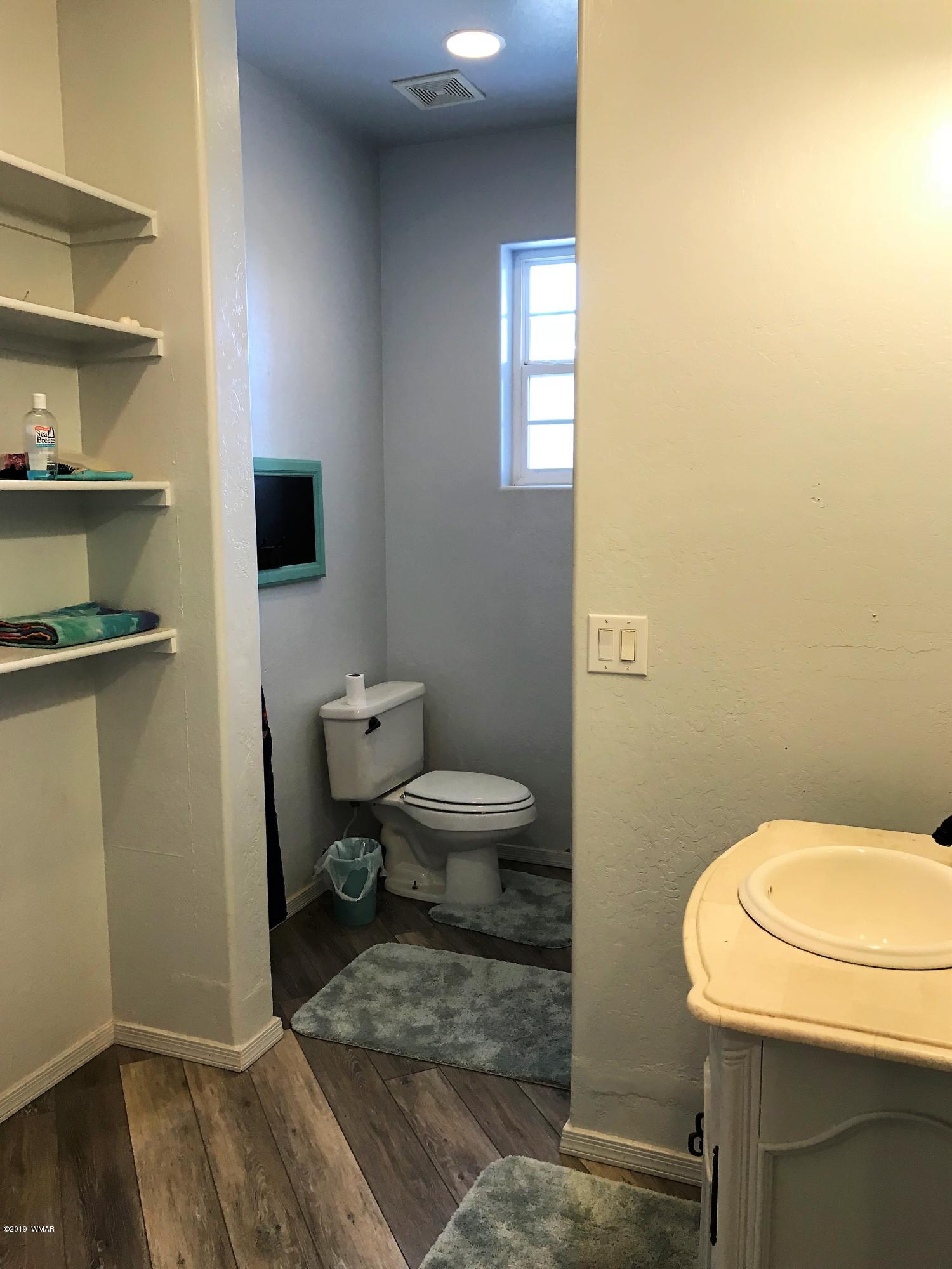 526 South 6th W Street Snowflake, AZ 85937 - Photo 33 of 36 a bathroom with a toilet a sink and a window