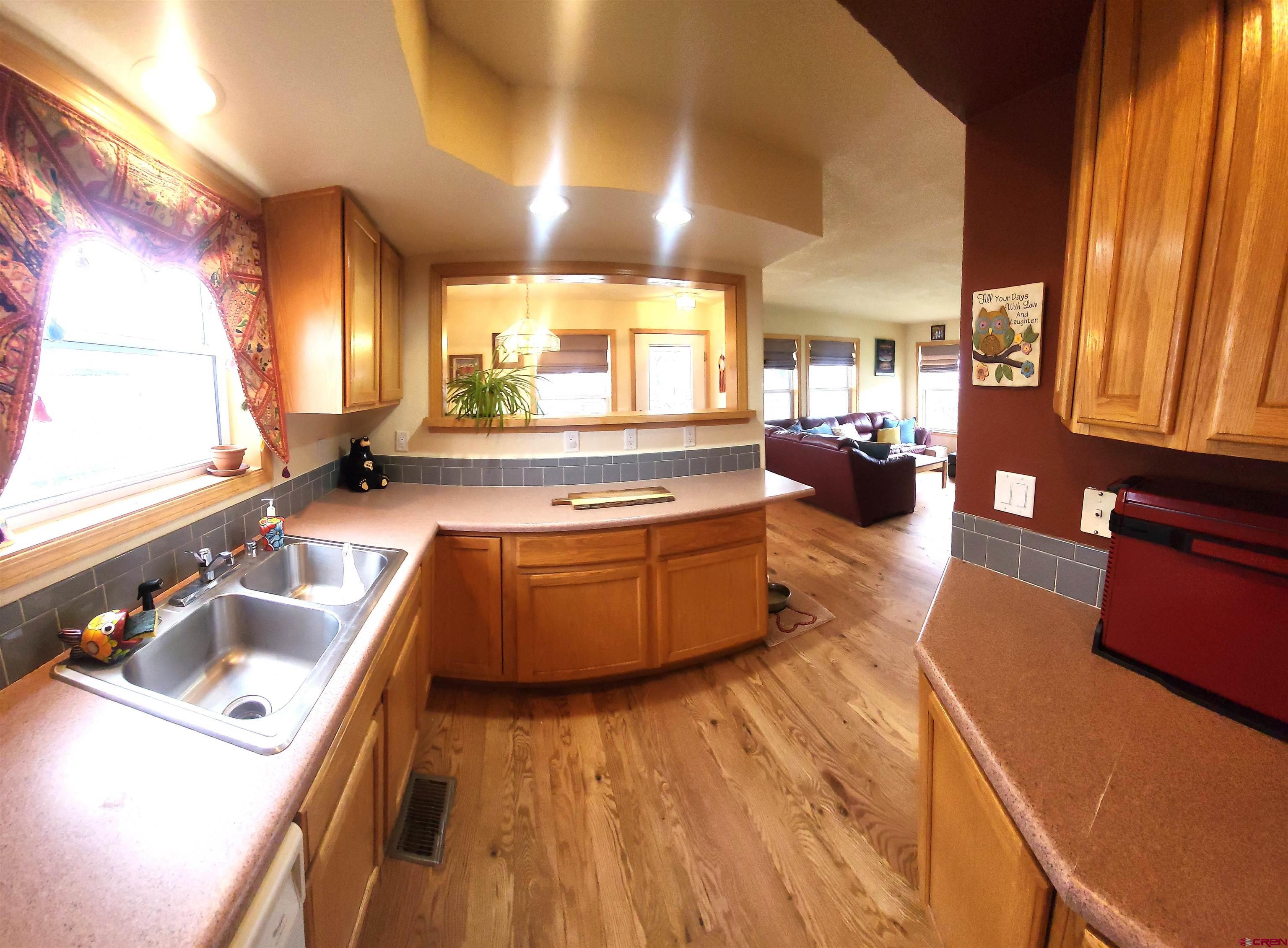 1610 Pine Street, Unit E Norwood, CO 81423 - Photo 11 of 23 a large kitchen with kitchen island a large counter space a sink a window and stainless steel appliances